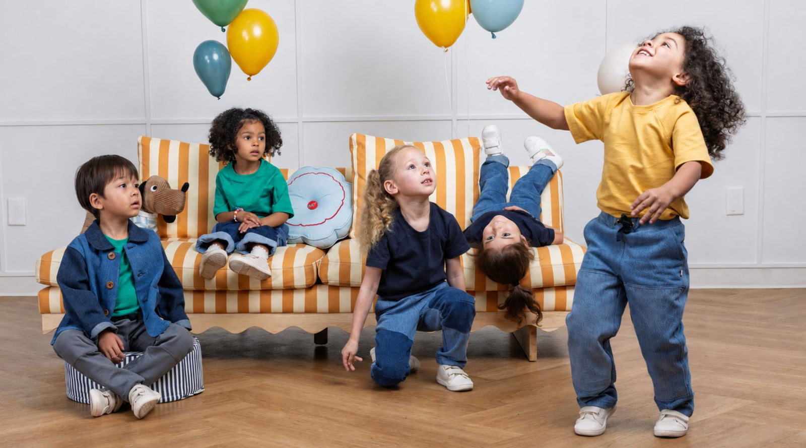 Kids playing with balloons, wearing comfortable sustainable clothes for active play