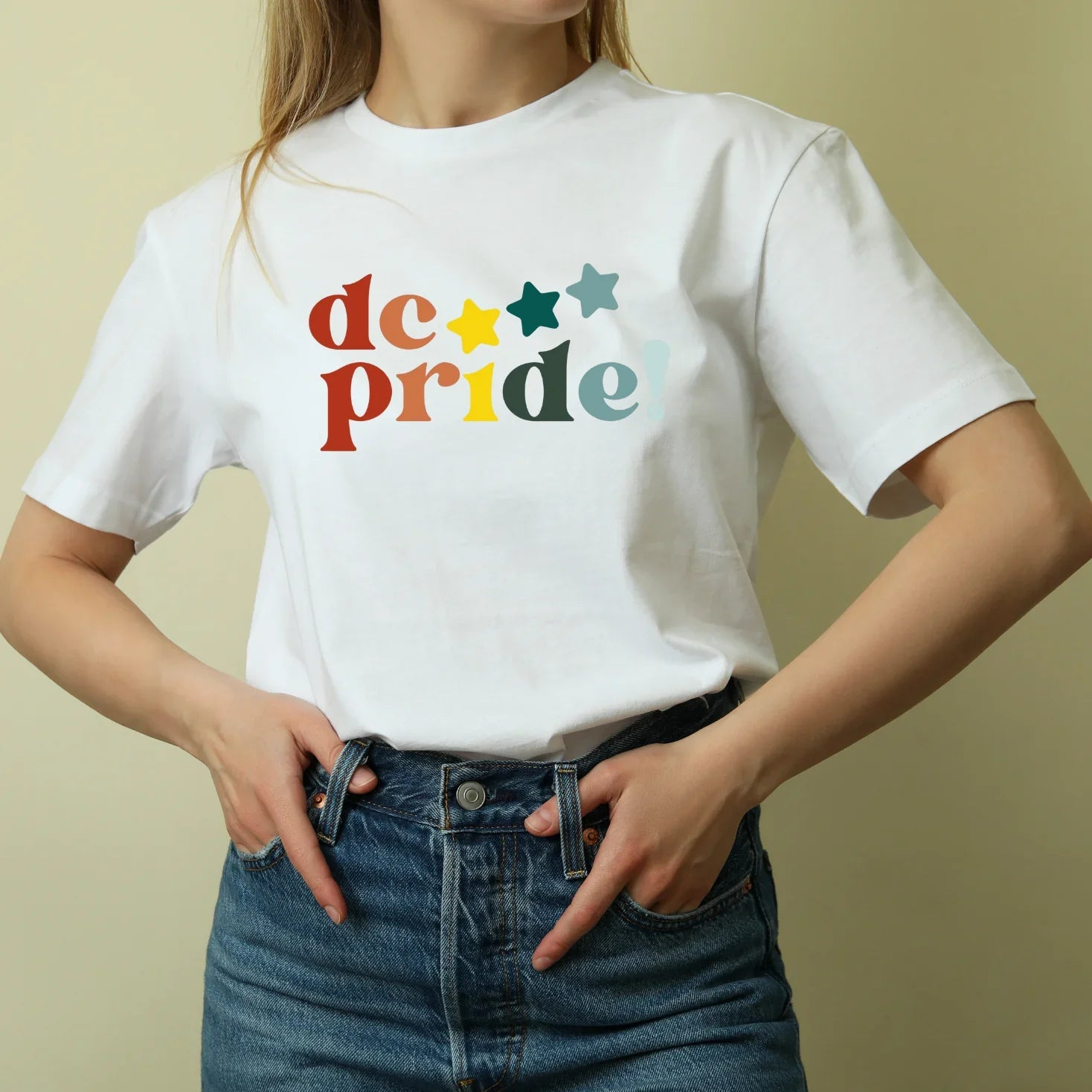 Woman wearing a white dc pride t-shirt with colorful stars, sustainable kids clothing by Jackalo