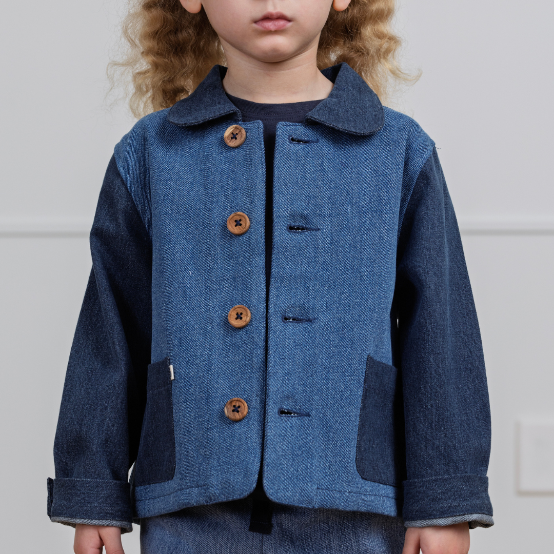 Child wearing durable denim jacket with wooden buttons and patch pockets, ideal for active play