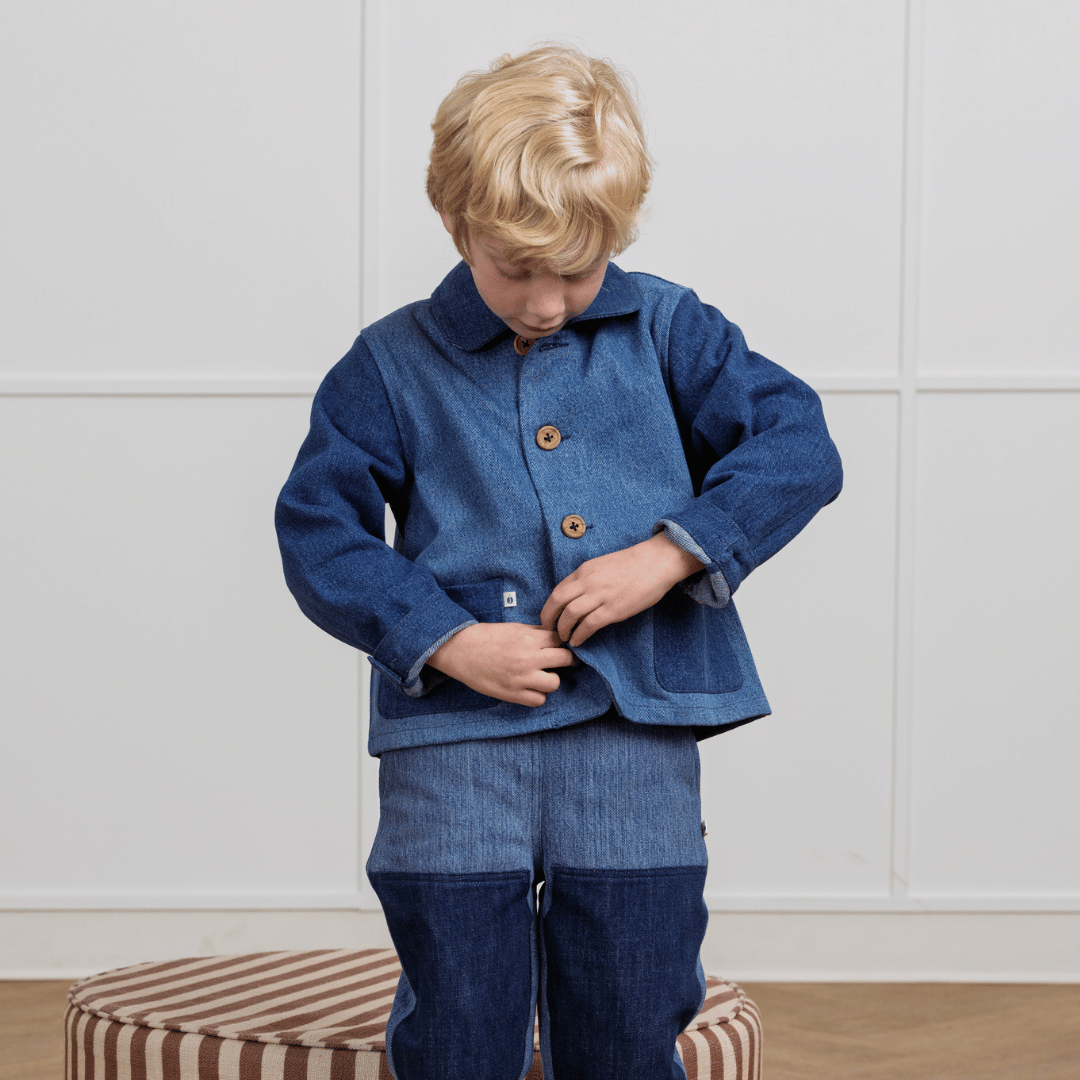 Child in durable denim jacket and pants, sustainable kids clothing for active play