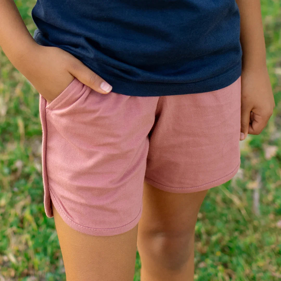 Child wearing soft pink active shorts with side pockets, perfect for playtime outdoors