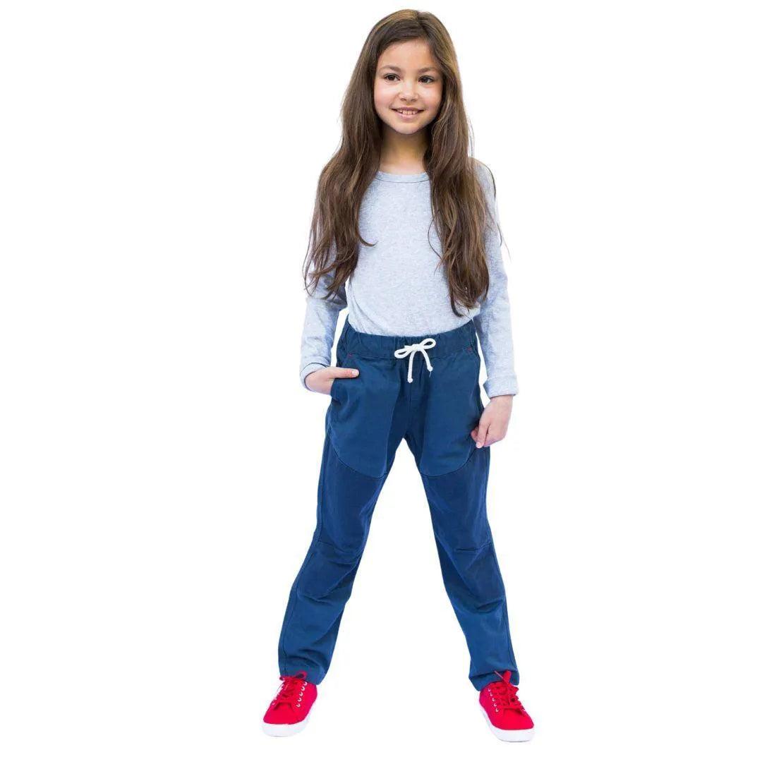 A young girl dressed in blue ash pants and a grey shirt
