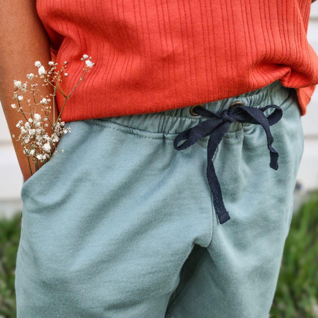 Cropped photo of a kid wearing teal shorts
