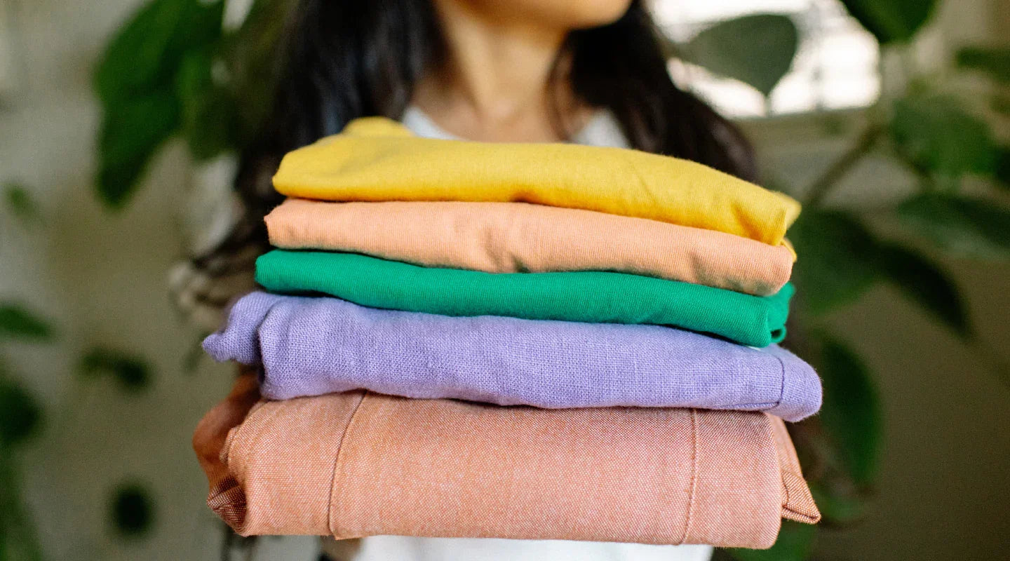 Colorful stack of sustainable kids clothes in vibrant hues, perfect for active play