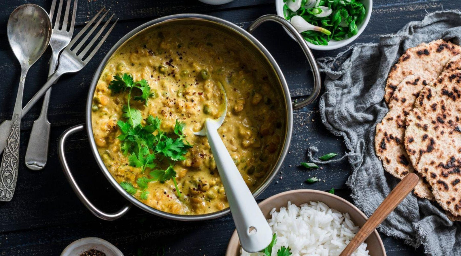 flatlay of dahl in a pot with rice and bread