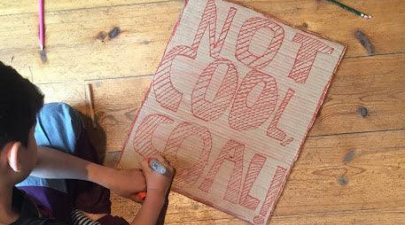 a young boy doodling on a paper
