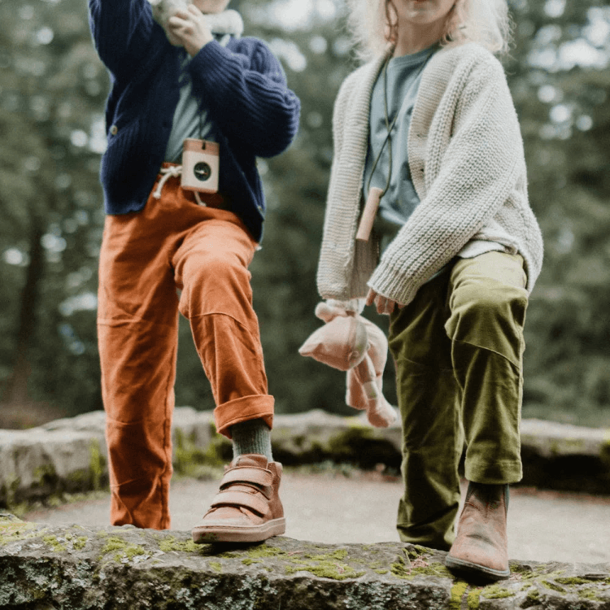 Two kids playing outside in corduroy pants