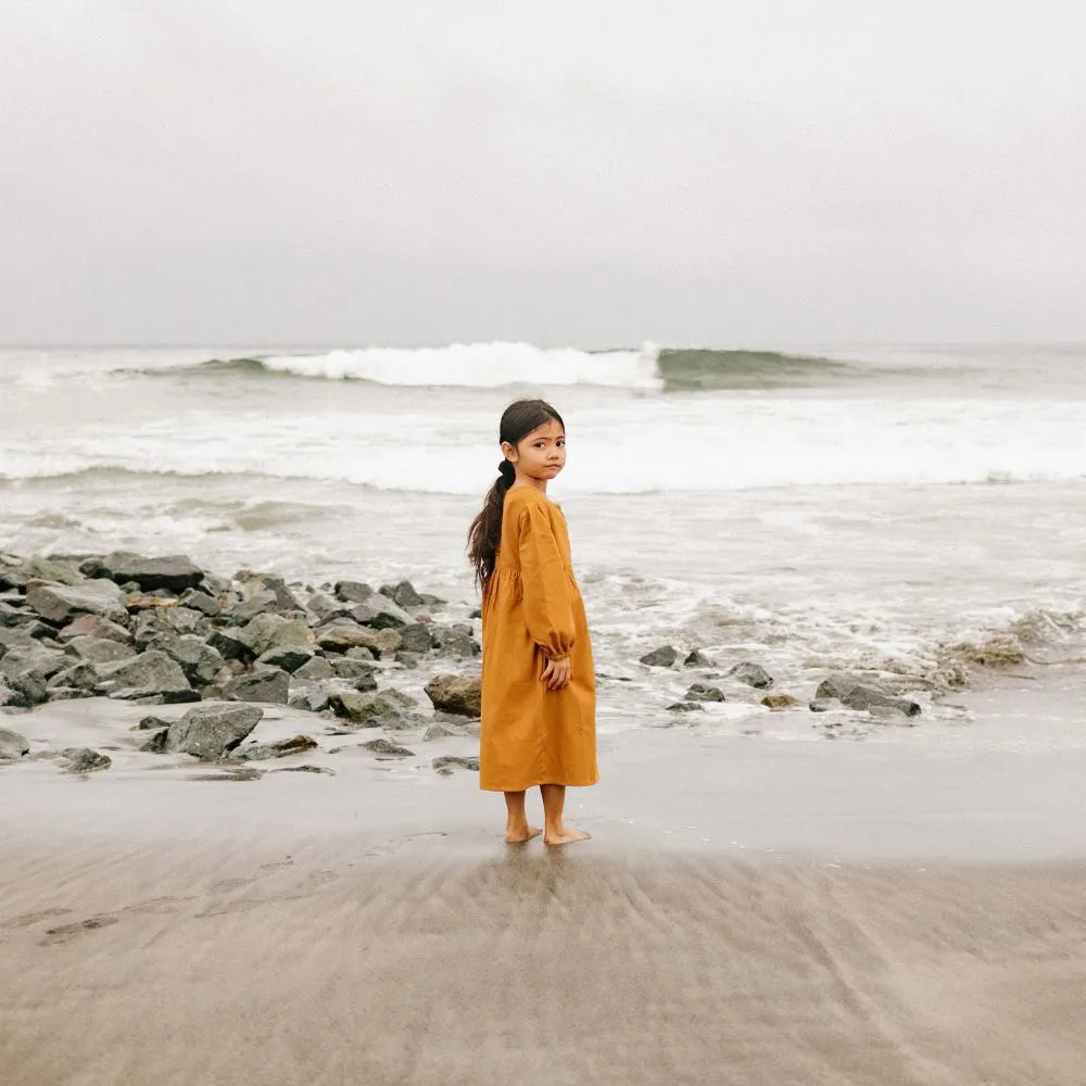 Girl in yellow dress on the shore