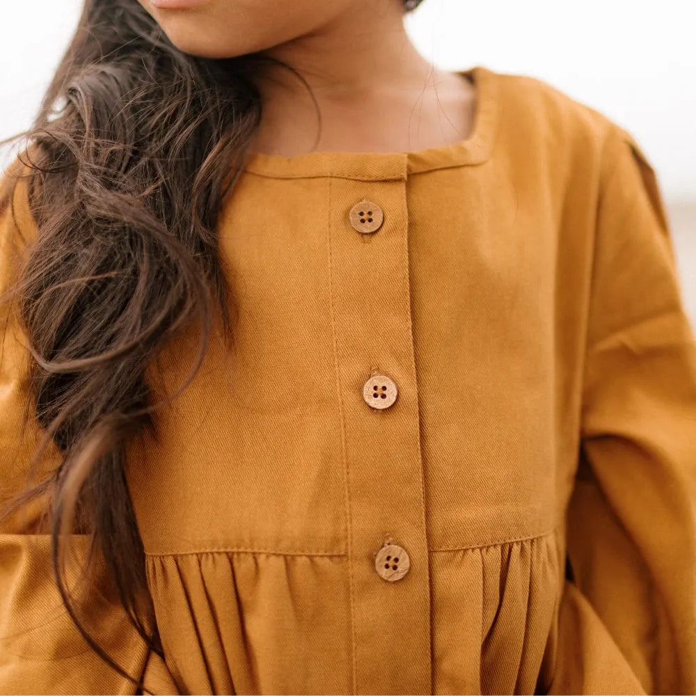 Closeup buttons on a mustard dress