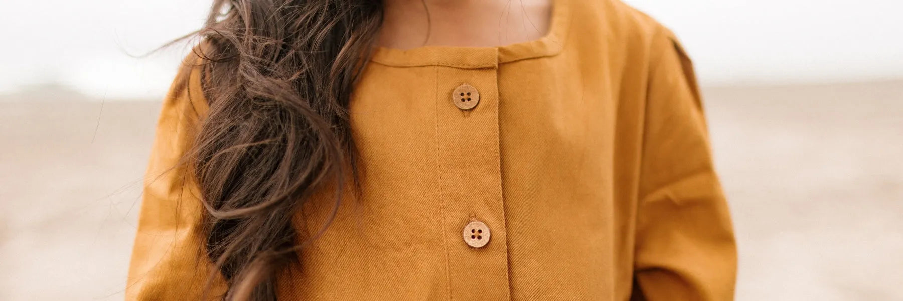 Closeup buttons on a mustard dress