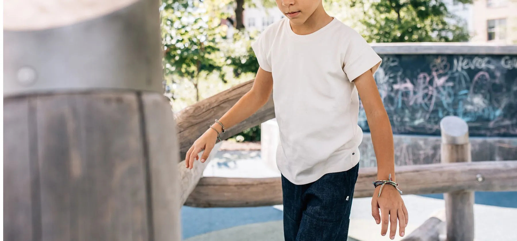 Boy in white shirt and blue jeans in playground