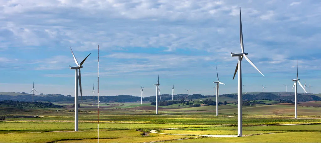 Wind turbines standing tall in a large open field