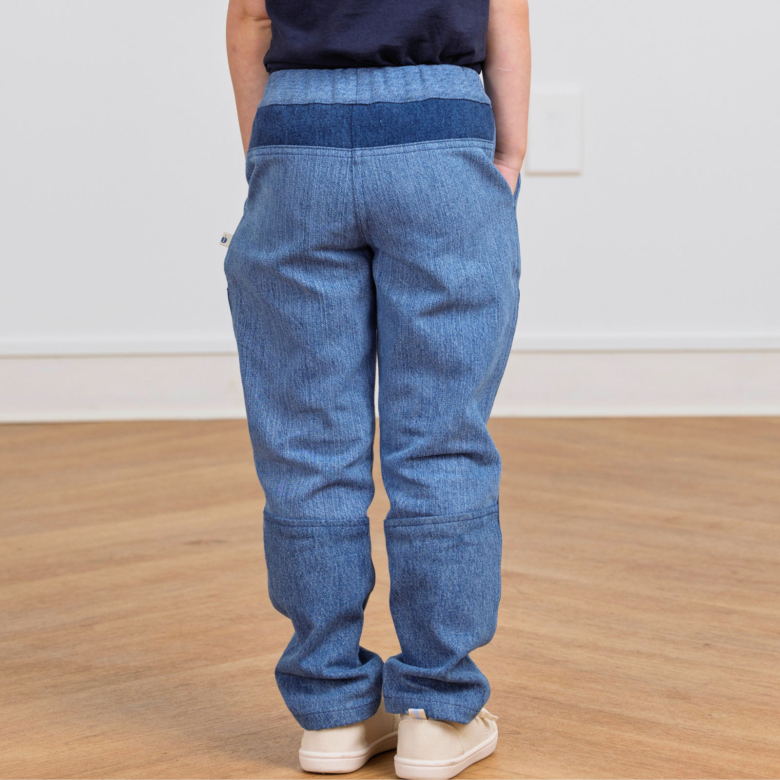 Kids' blue denim-style pants with elastic waist, back view, sustainable active wear