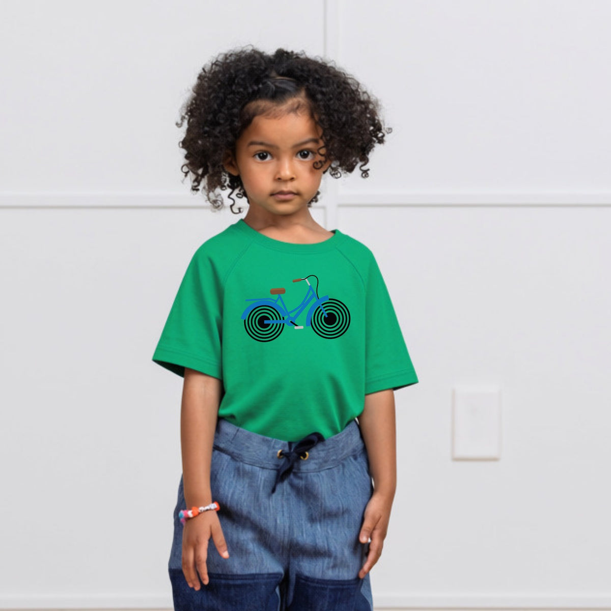 Girl in green t-shirt with Bike print on it. Organic cotton t-shirt from Jackalo.