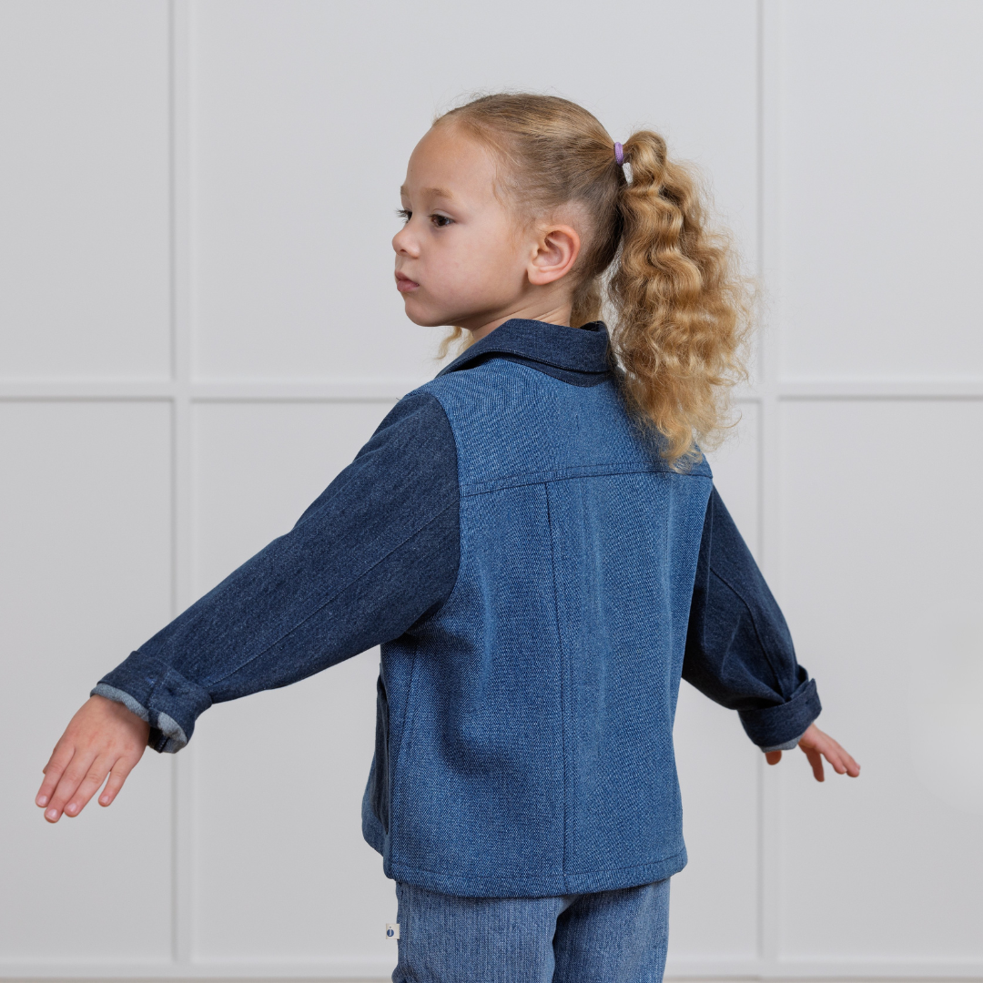 Toddler in blue denim-style active kids jacket and pants, side view, sustainable clothing
