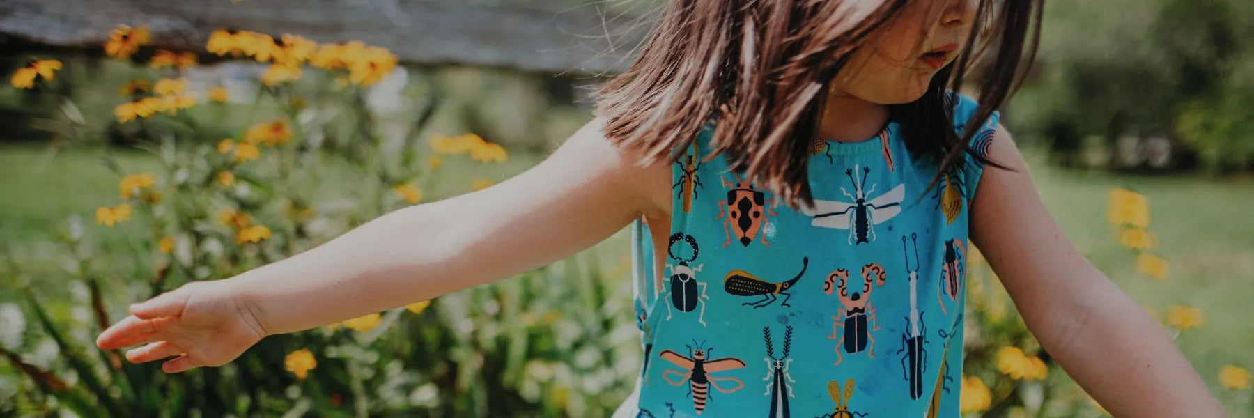 Girl in a field wearing a beetle printed dress