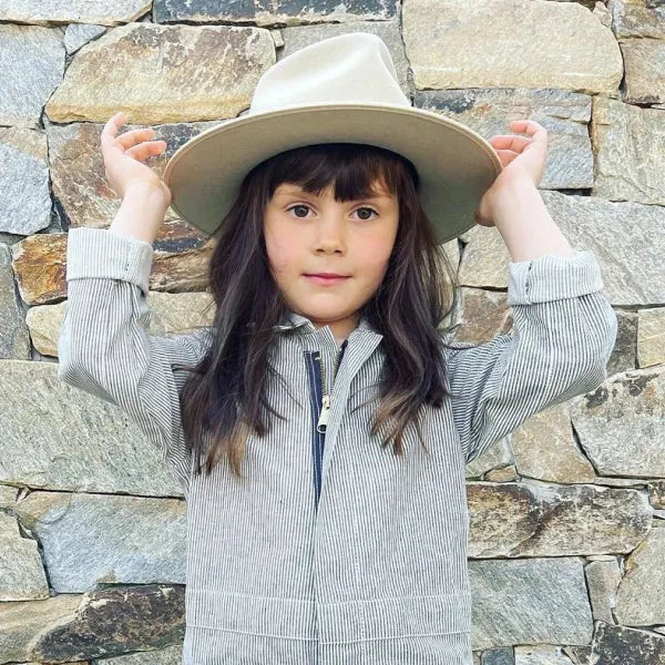 Young girl wearing a coverall and a hat