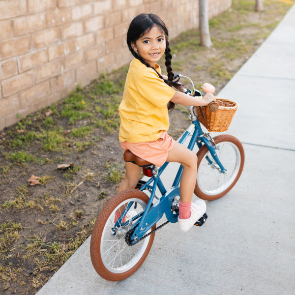 Girl kid wearing yellow shirt riding a bicycle