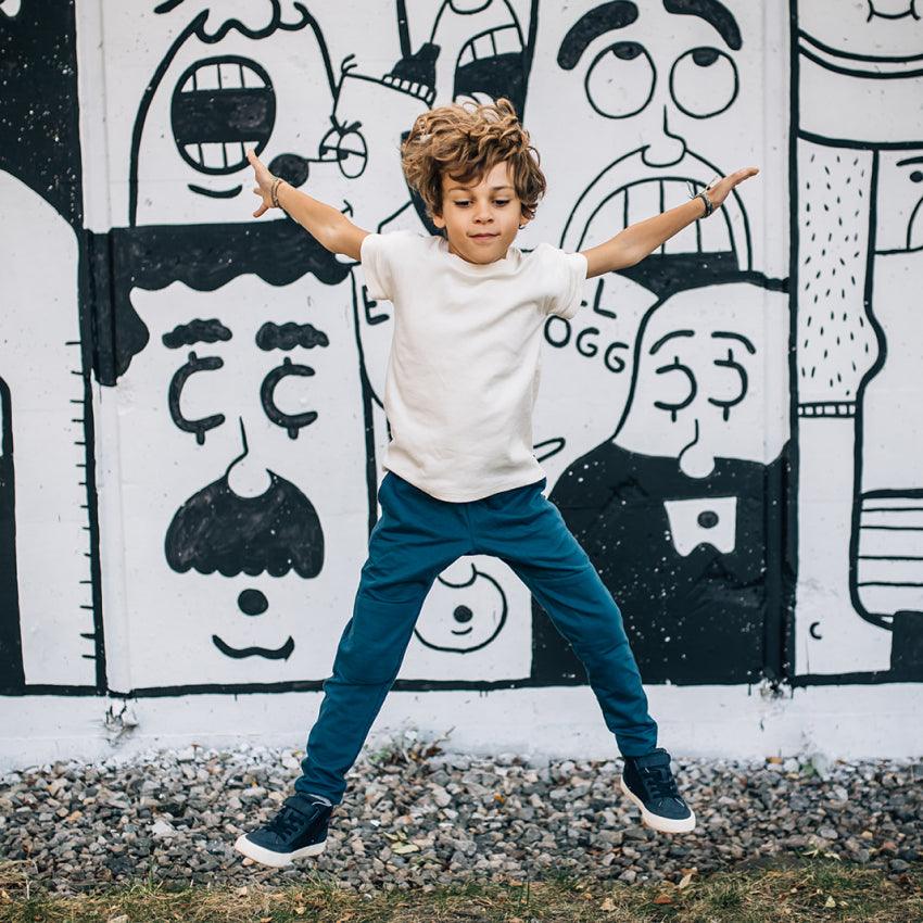 Boy juping in the air in front of graffiti wall