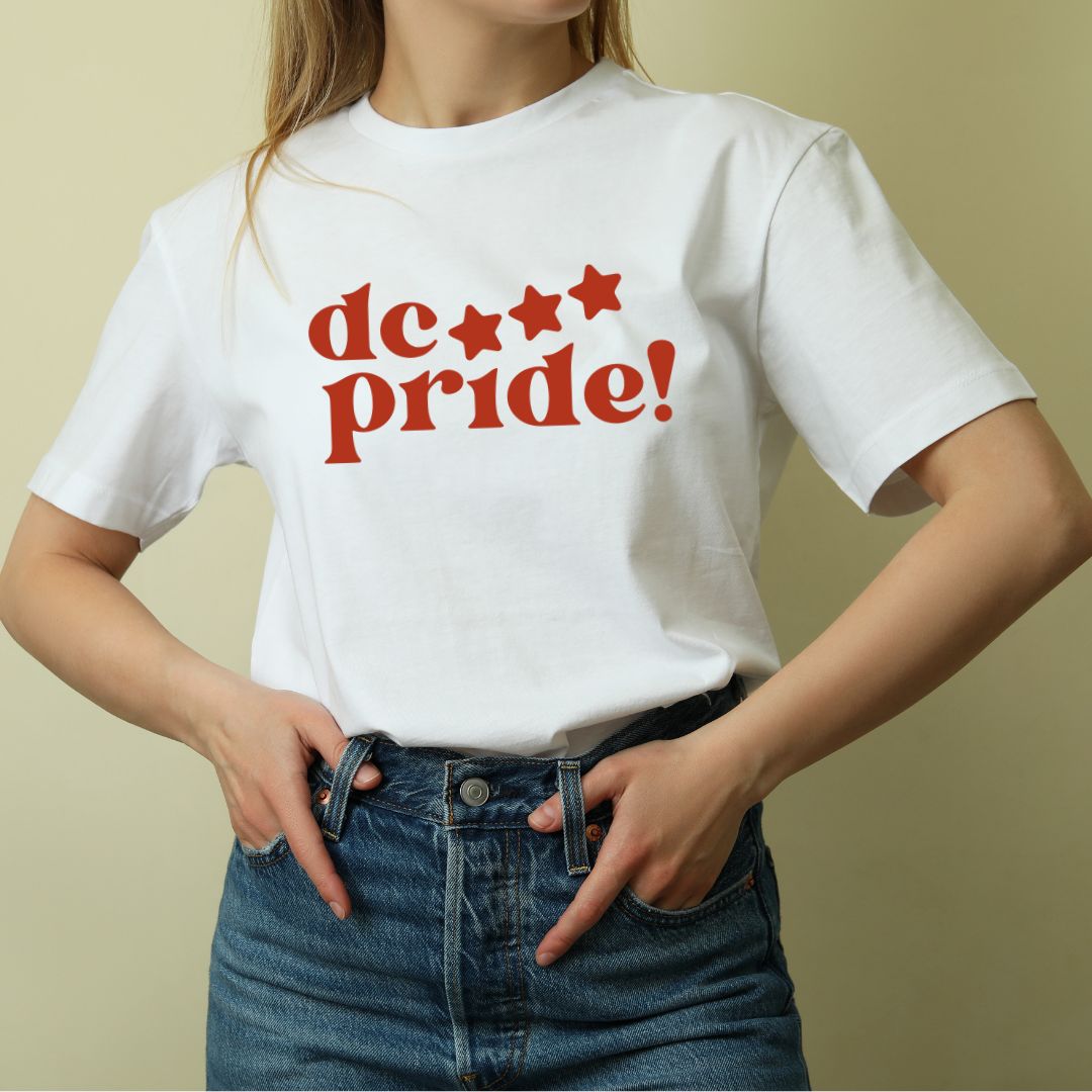 White t-shirt with red 'dc pride!' text and stars, worn with denim jeans
