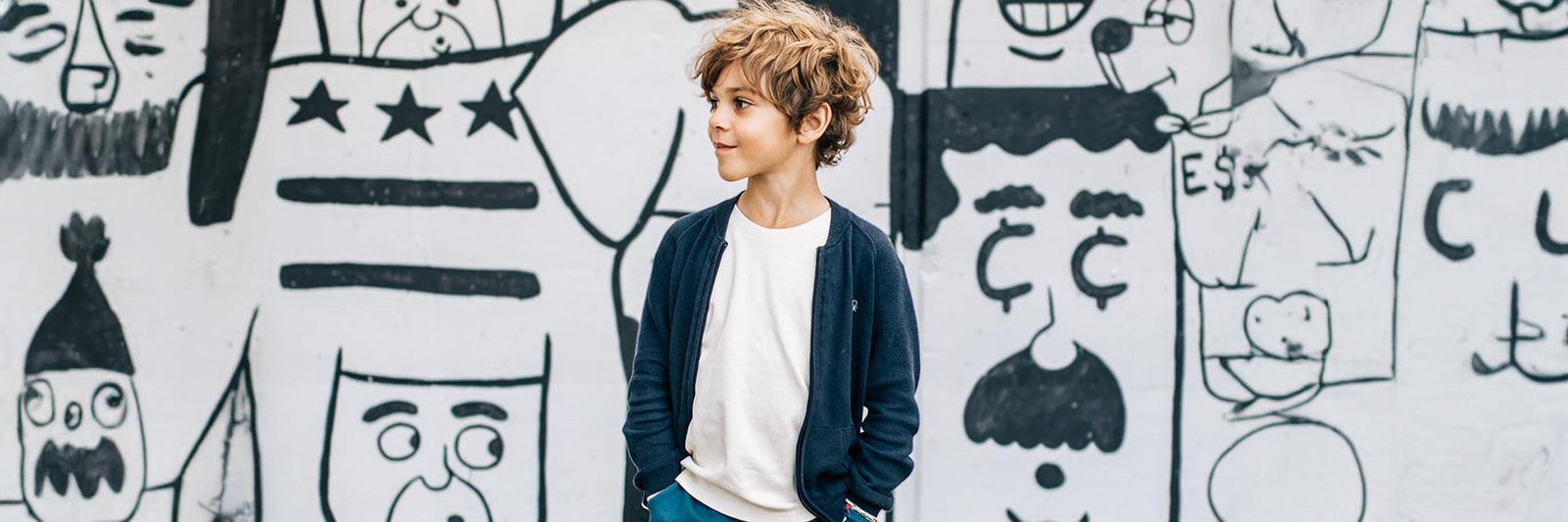 Boy standing in front of graffiti wall