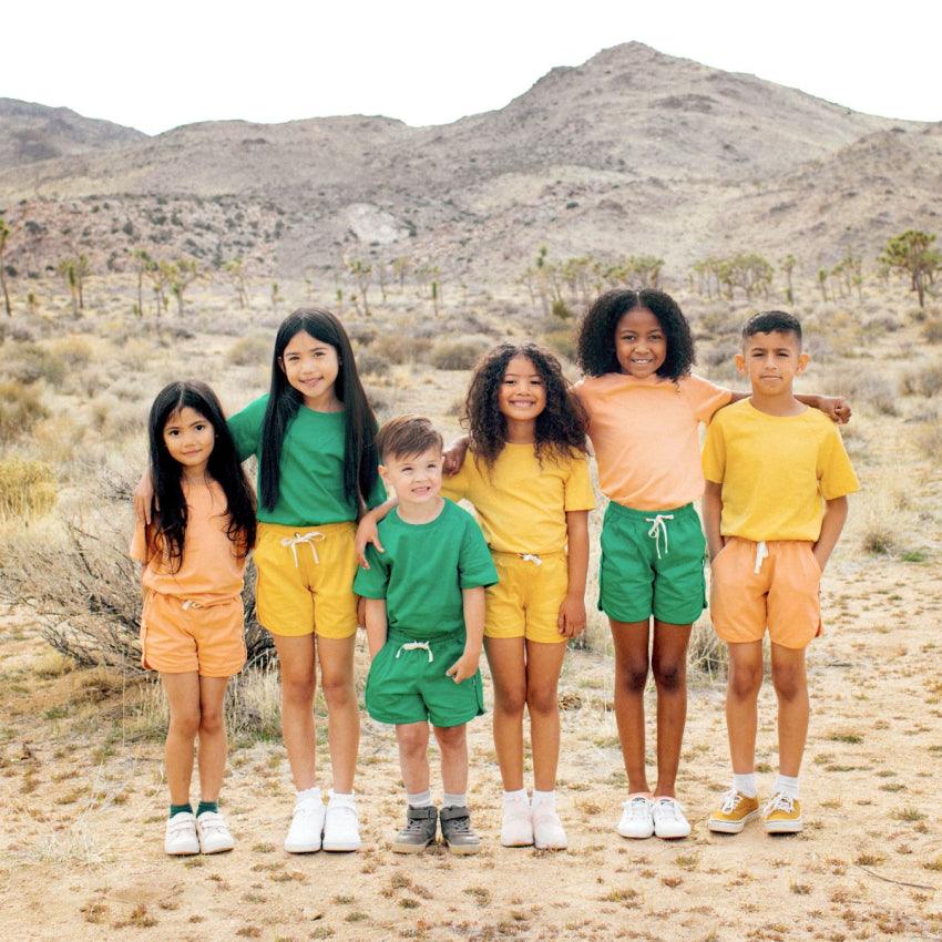 A fun group of kids in yellow, green and peach shirt and short set