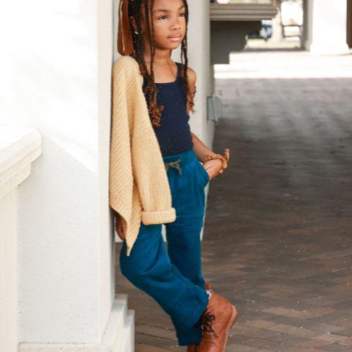  A young girl in a blue top and brown boots
