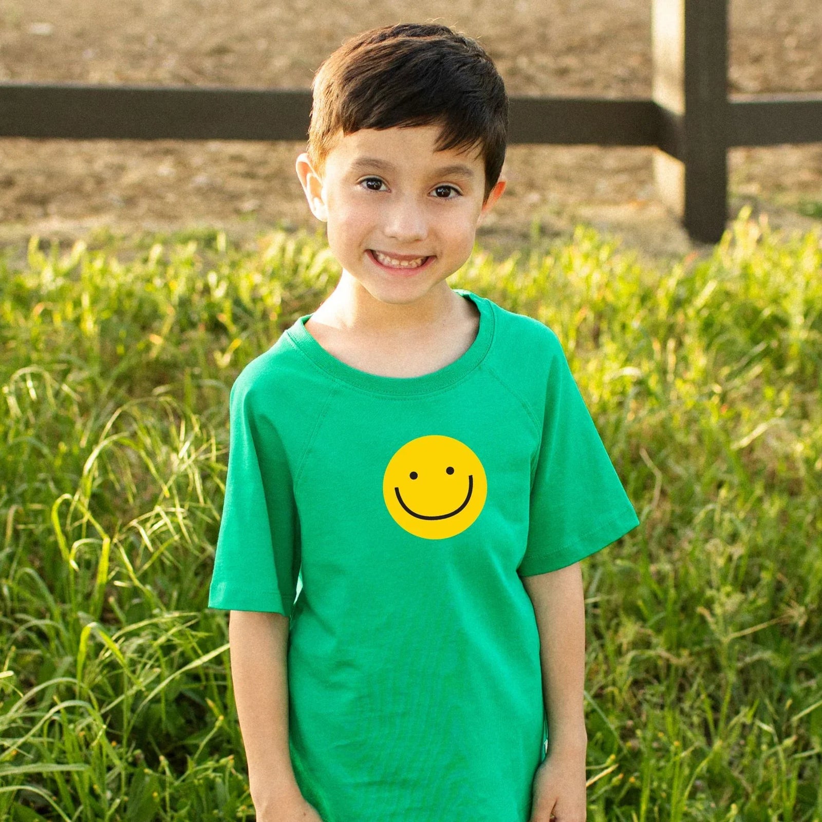Green t-shirt with a yellow smiley face on a white background
