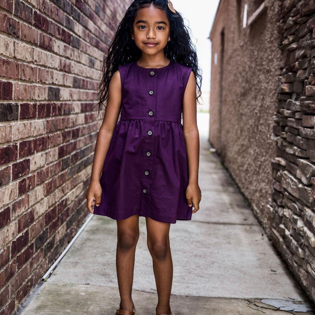 Smiling young girl wearing purple dress