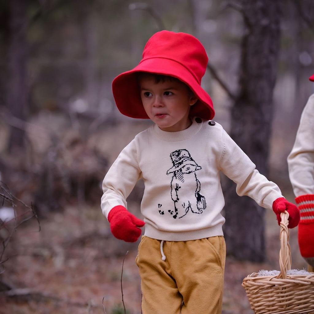 Kid in red hat carrying basket